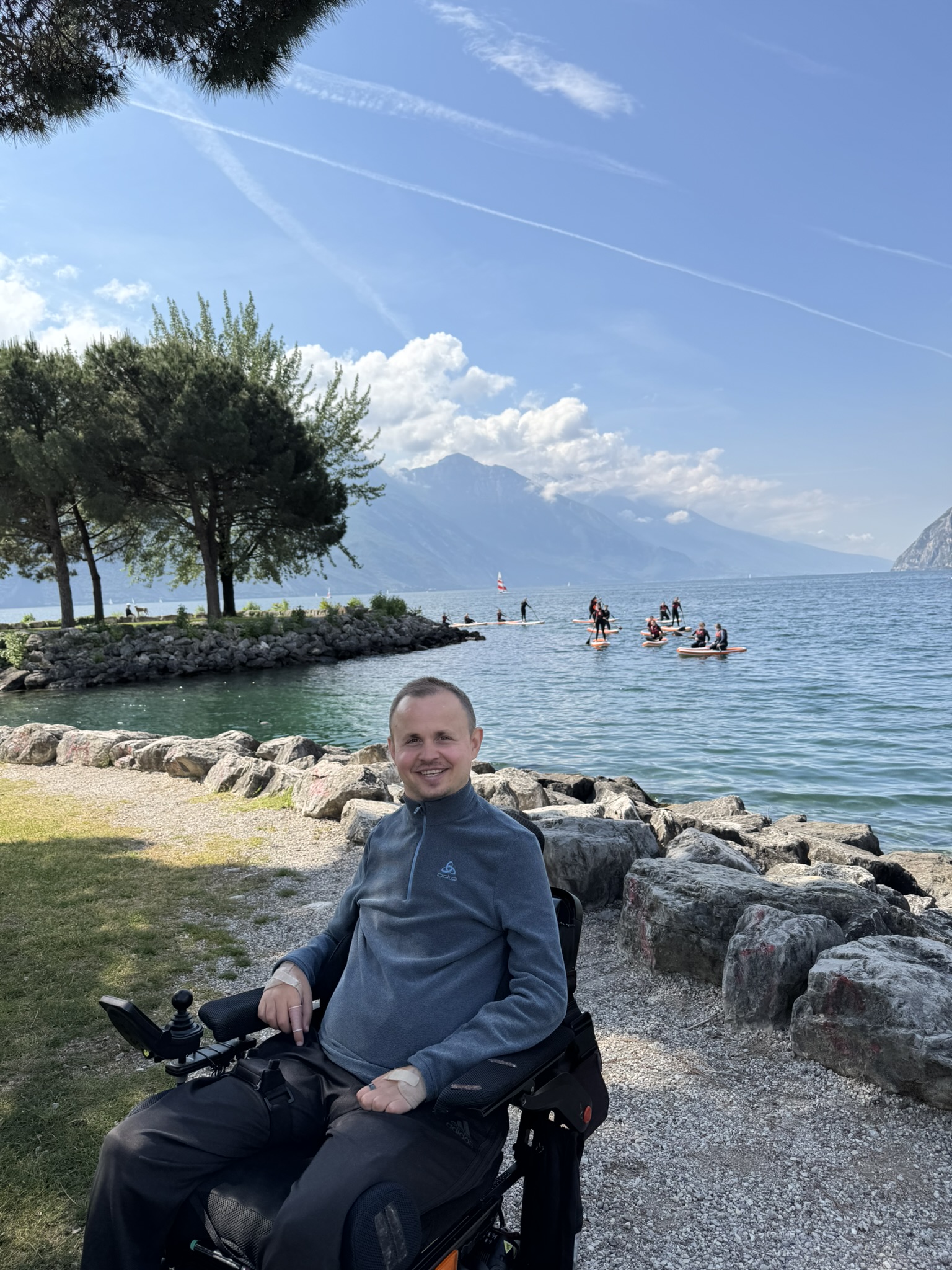 Andrei Chiricheș lächelt in die Kamera, am See in seinem Rollstuhl.